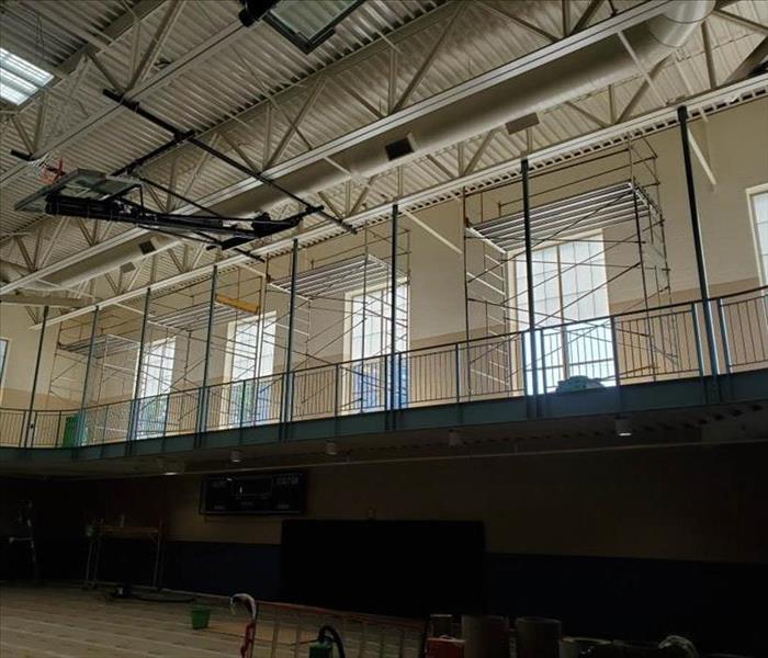 scaffolding on the upper level of a gymnasium put in place in order to provide fire damage restoration service.